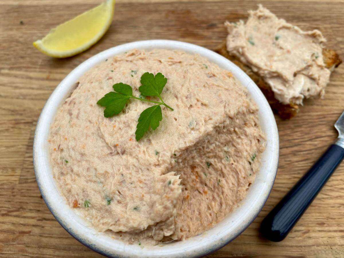 Kipper pate in bowl with parsley and lemon slice.
