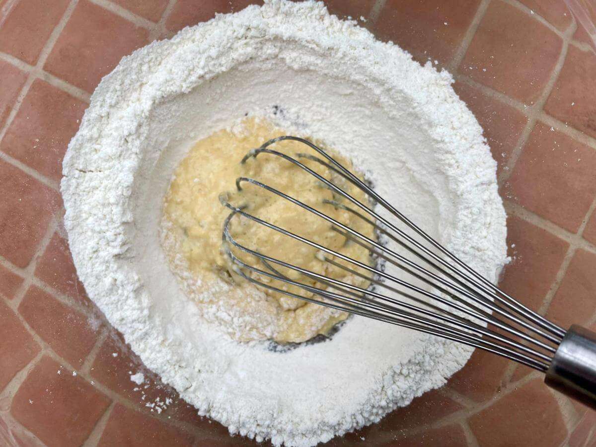 Mixing egg into flour.