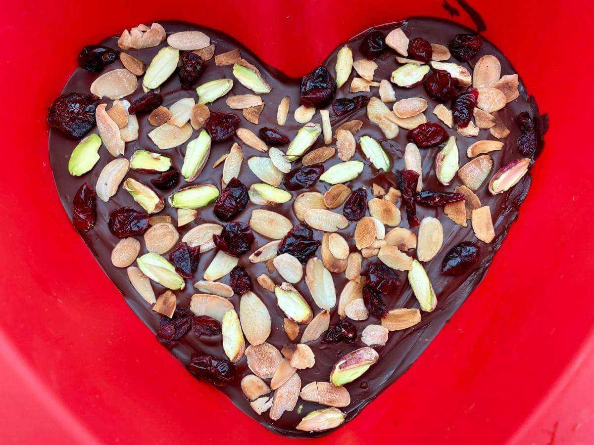 Chocolate heart decorated with nuts.