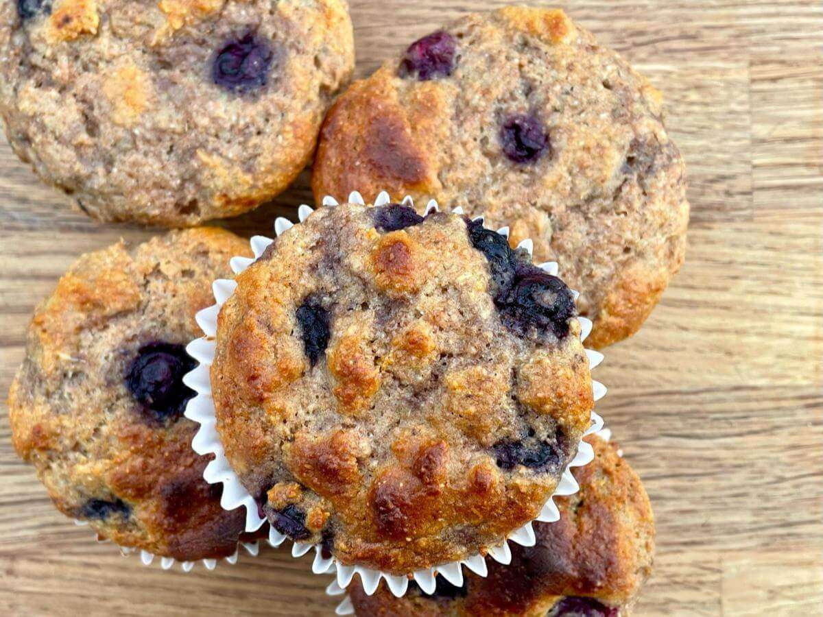 Blueberry spelt muffins on wooden board.