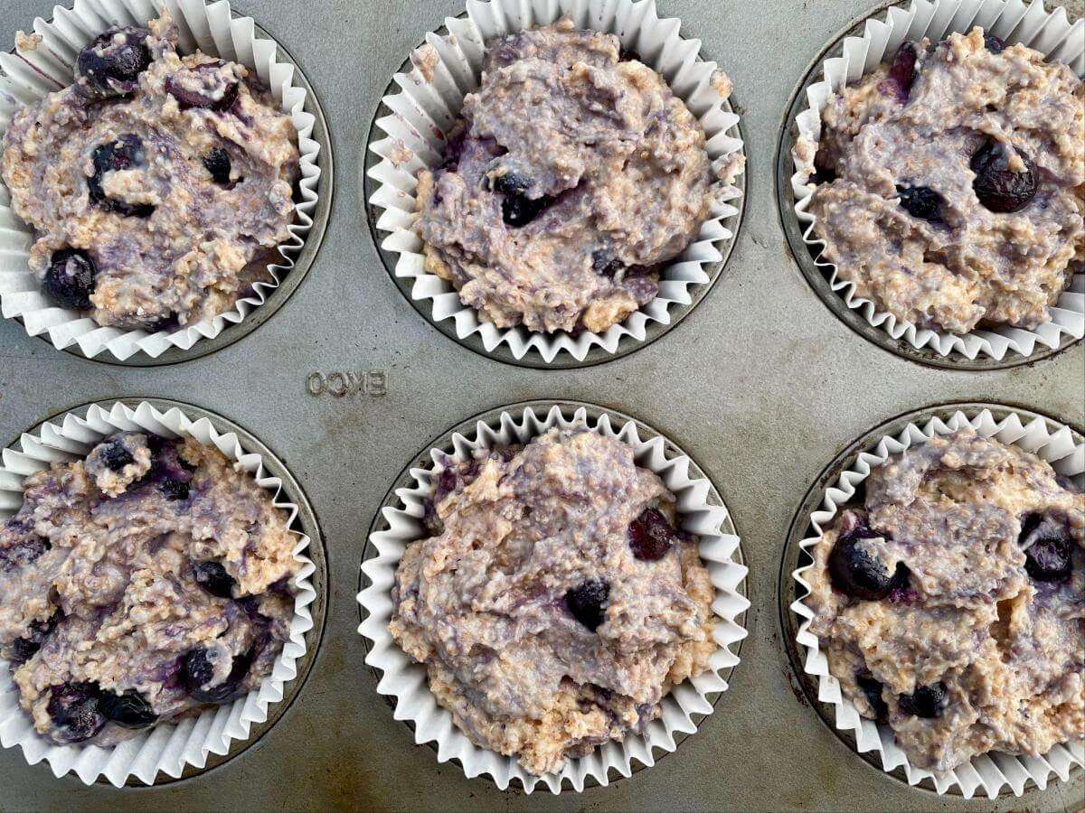 Spelt blueberry muffin batter in paper cases.