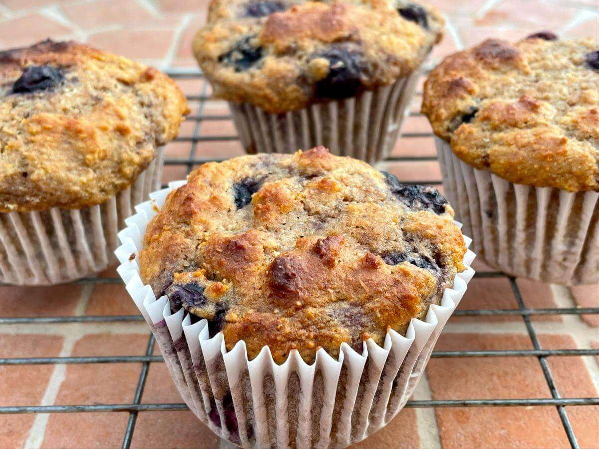 Spelt blueberry muffins on wire rack.