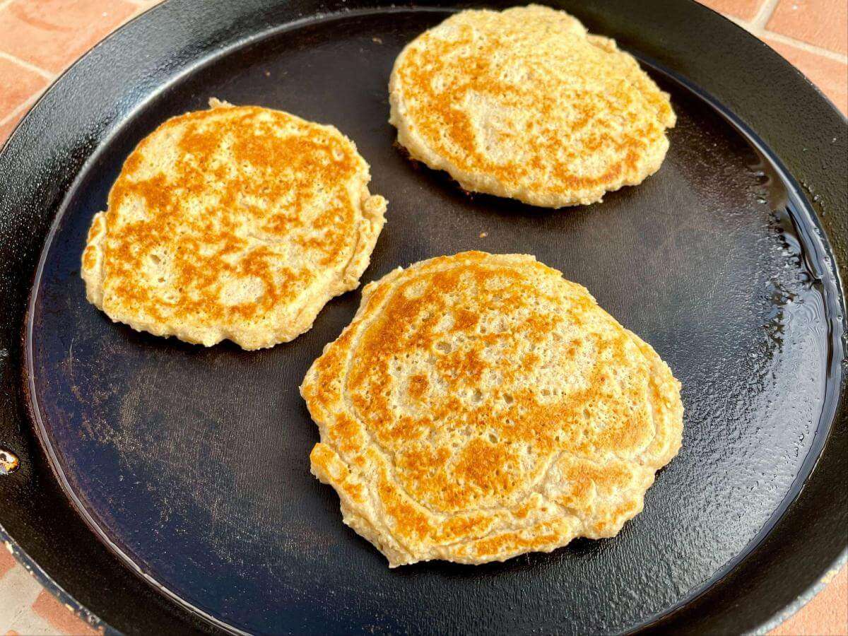 Golden brown pancakes in pan.
