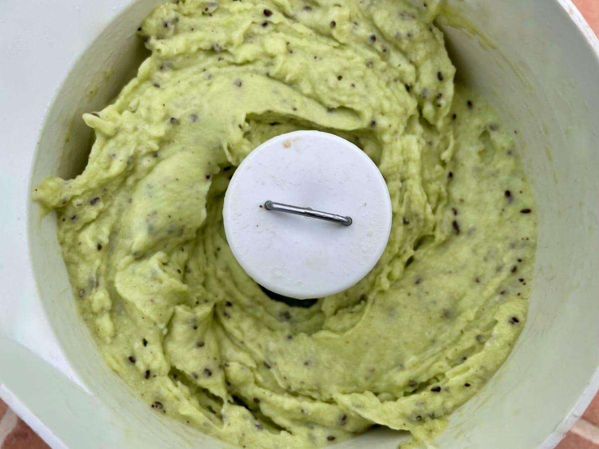 Kiwi fruit and honey in food processor.