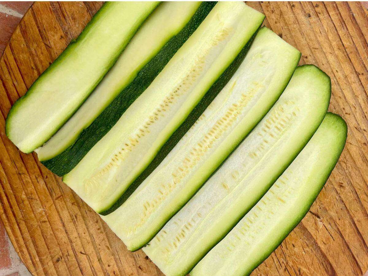 Sliced courgette on wooden board.