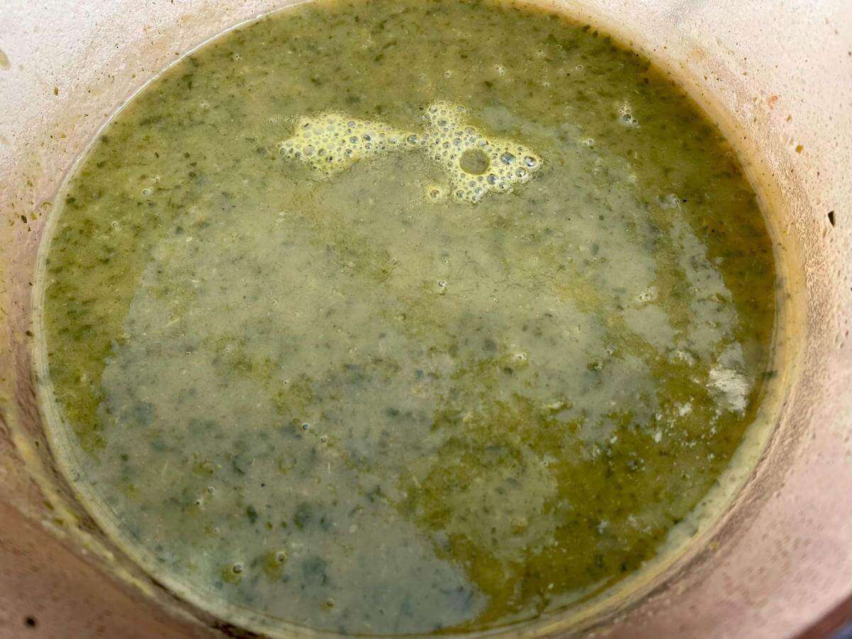Carrot greens soup in pan.