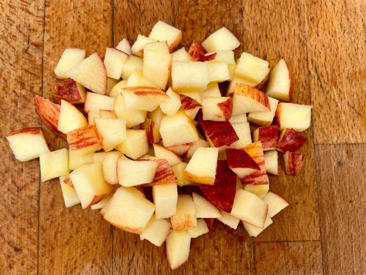 Diced apple on wooden chopping board.