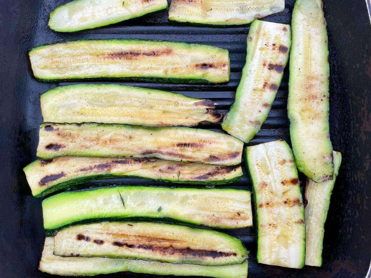 Griddled courgettes in pan.