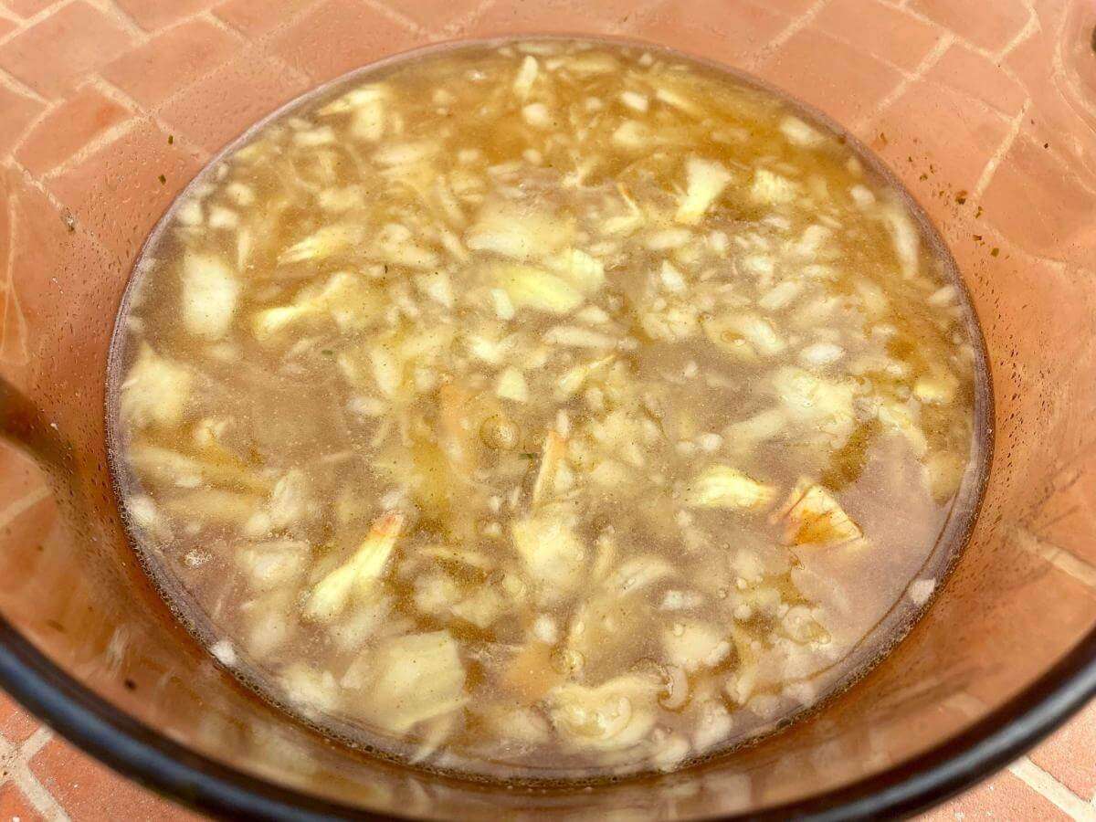 Onions potato and stock in pan.