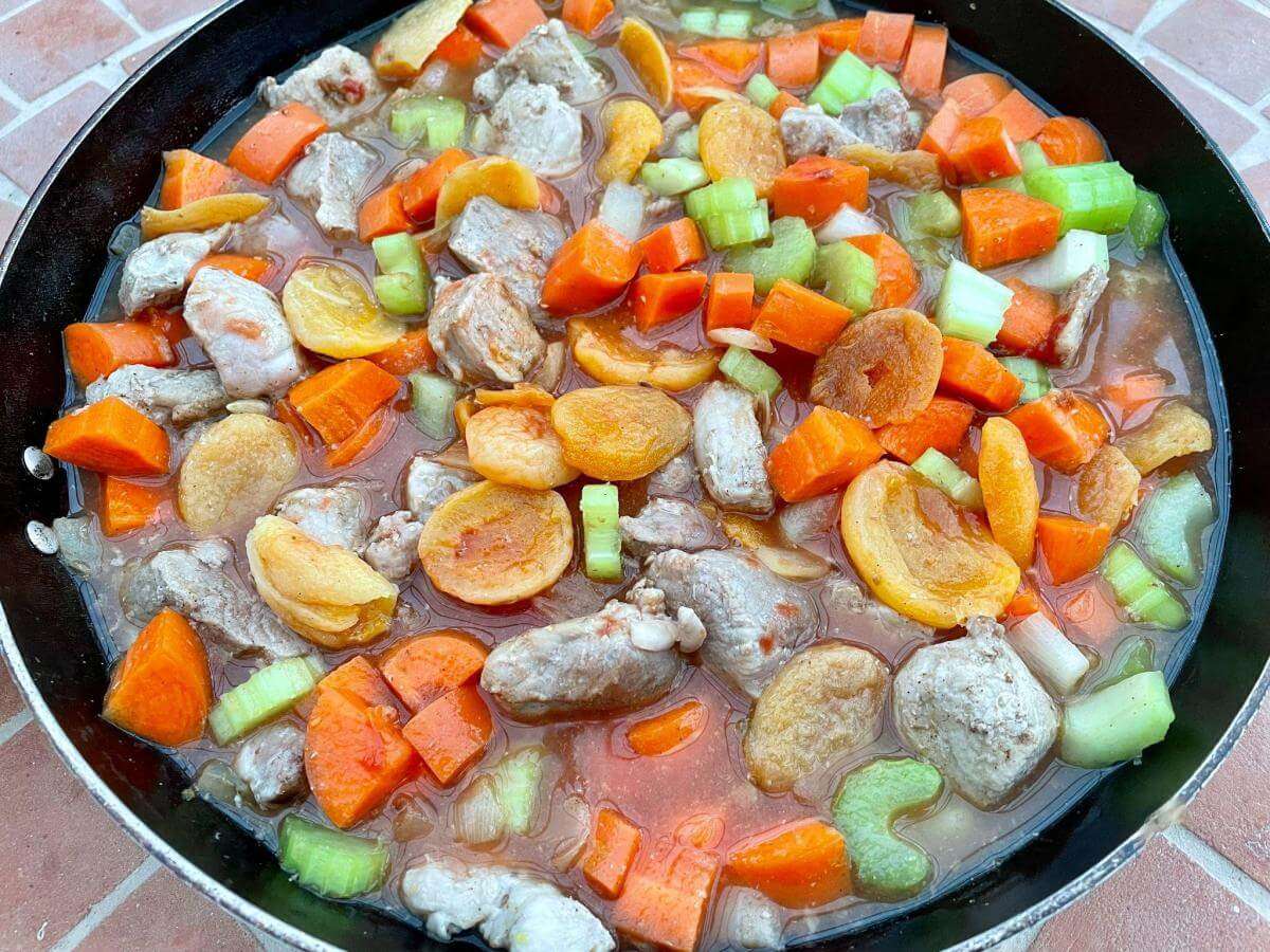 Pork, apricots and vegetables in stock.